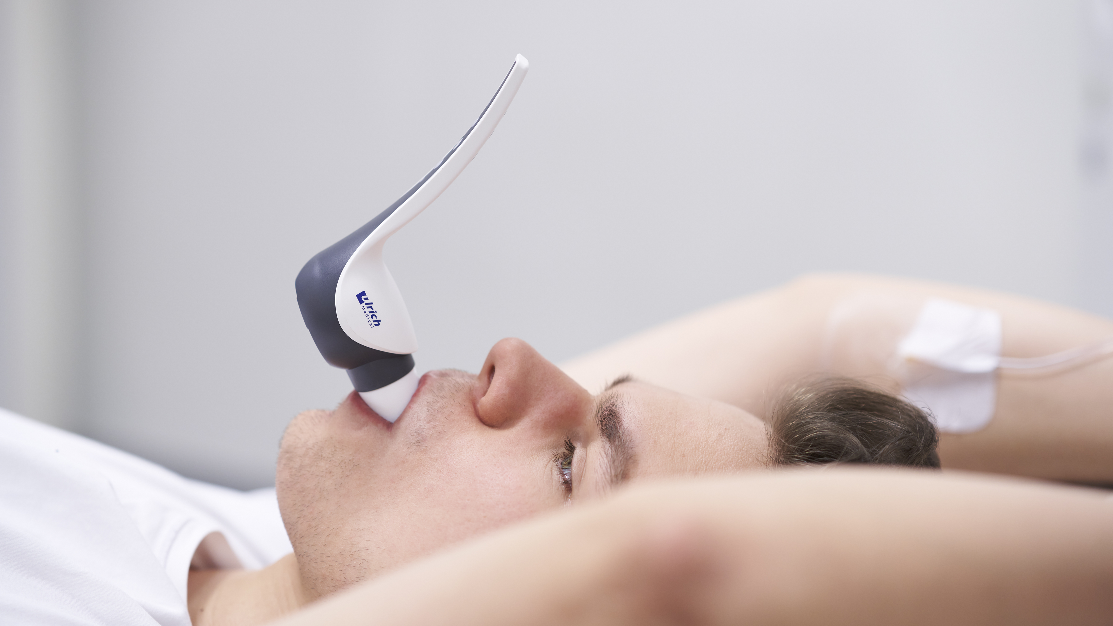 A patient has the Contrast Booster from ulrich medical in his mouth for a pulmonary embolism CT scan.